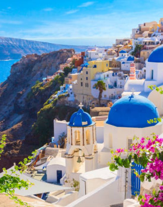 Santorini island, Greece. Oia town traditional white houses and churches with blue domes over the Caldera, Aegean sea.